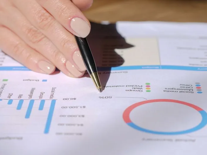 Dirigeant relisant et annotant un prévisionnel, stylo en main